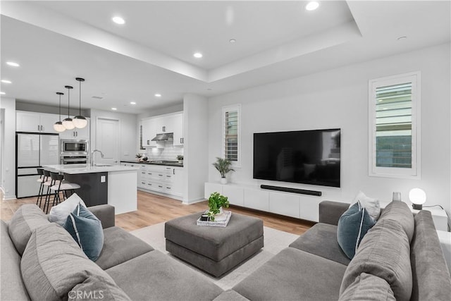 40 Jarano St, Rancho Mission Viejo, CA 92694 - living area featuring light wood-type flooring, a raised ceiling, and recessed lighting