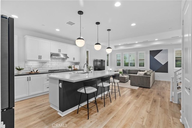 40 Jarano St, Rancho Mission Viejo, CA 92694 - kitchen with under cabinet range hood, a sink, freestanding refrigerator, stainless steel gas cooktop, and a kitchen breakfast bar
