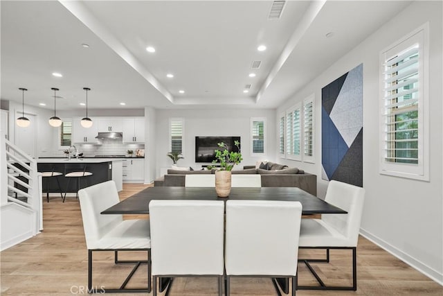 40 Jarano St, Rancho Mission Viejo, CA 92694 - dining room featuring recessed lighting, light wood-style floors, a tray ceiling, and baseboards