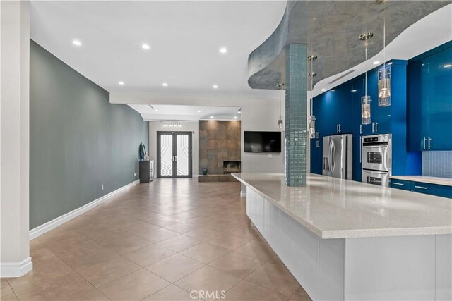 17206 Nugent Pl, Granada Hills, CA 91344 - kitchen featuring stainless steel appliances, blue cabinets, modern cabinets, open floor plan, and light tile patterned flooring