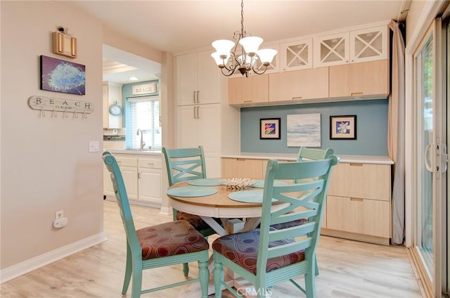8788 Coral Springs Ct Unit 206A, Huntington Beach, CA 92646 - dining space featuring a chandelier, light wood-style flooring, and baseboards