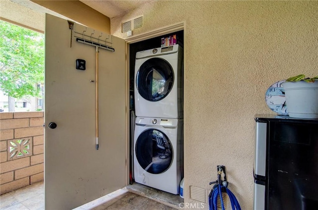 8788 Coral Springs Ct Unit 206A, Huntington Beach, CA 92646 - laundry area with stacked washer / drying machine and a textured wall