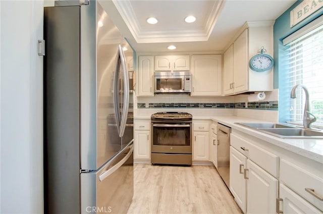 8788 Coral Springs Ct Unit 206A, Huntington Beach, CA 92646 - kitchen featuring stainless steel appliances, a sink, crown molding, a tray ceiling, and recessed lighting