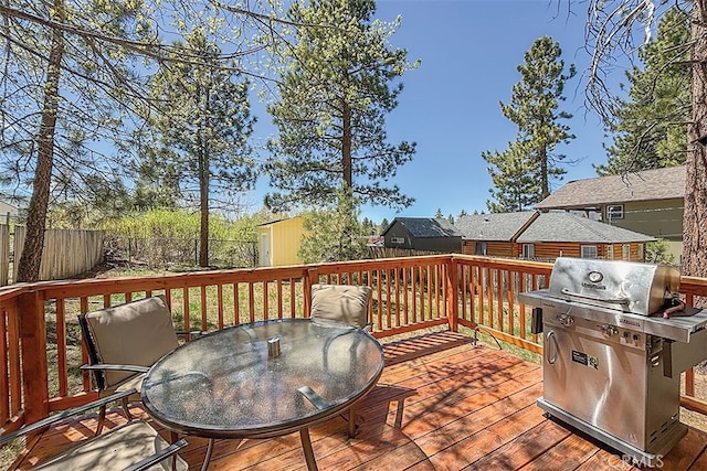 670 Marin Rd, Big Bear Lake, CA 92315 - wooden terrace featuring a grill, outdoor dining space, a fenced backyard, and an outdoor structure