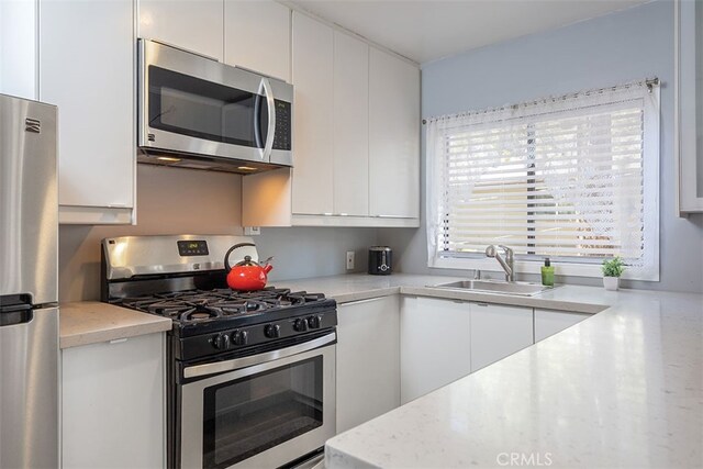 670 Marin Rd, Big Bear Lake, CA 92315 - kitchen with stainless steel appliances, a sink, white cabinets, modern cabinets, and light stone countertops