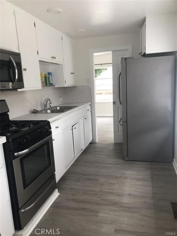 3512 Palm Ave, Manhattan Beach, CA 90266 - kitchen featuring appliances with stainless steel finishes, white cabinets, a sink, and dark wood-type flooring