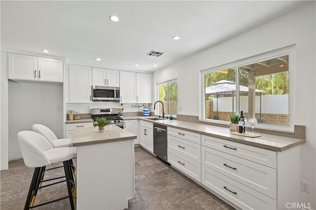 27834 Lassen St, Castaic, CA 91384 - kitchen featuring stainless steel appliances, white cabinetry, a center island, recessed lighting, and light countertops