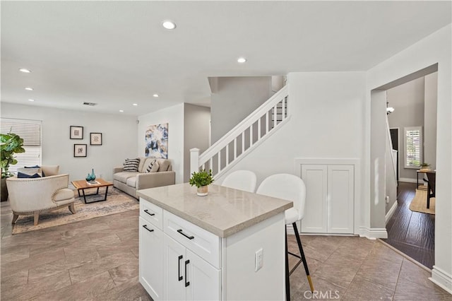 27834 Lassen St, Castaic, CA 91384 - kitchen with a breakfast bar, a center island, white cabinetry, recessed lighting, and open floor plan