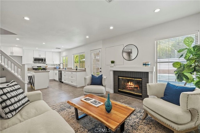 27834 Lassen St, Castaic, CA 91384 - living area featuring recessed lighting, a brick fireplace, stairs, and stone tile floors
