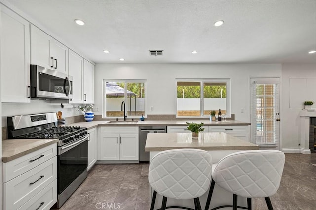 27834 Lassen St, Castaic, CA 91384 - kitchen featuring stainless steel appliances, a kitchen breakfast bar, recessed lighting, white cabinets, and light countertops
