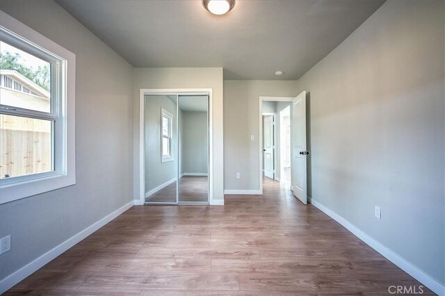 784 W 17th St, San Bernardino, CA 92405 - unfurnished bedroom featuring a closet, wood finished floors, and baseboards