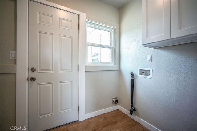 784 W 17th St, San Bernardino, CA 92405 - laundry area featuring cabinet space, baseboards, hookup for a washing machine, wood finished floors, and a textured wall