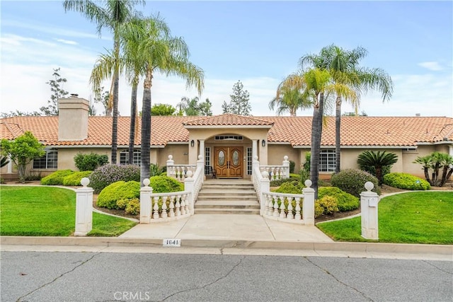 1641 Ford St, Redlands, CA 92373 - mediterranean / spanish house with stucco siding, a tiled roof, a front yard, and a chimney