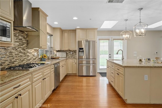 1641 Ford St, Redlands, CA 92373 - kitchen featuring stainless steel appliances, wall chimney range hood, a sink, a skylight, and recessed lighting