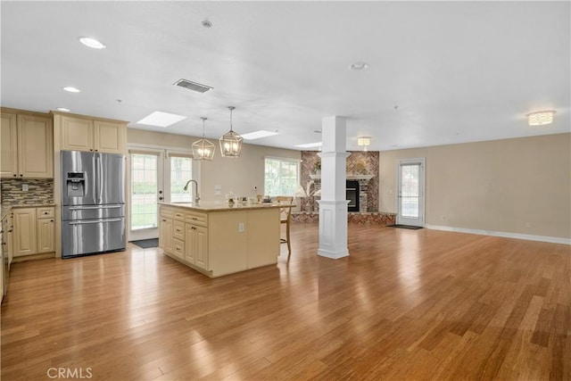 1641 Ford St, Redlands, CA 92373 - kitchen featuring stainless steel fridge, open floor plan, a kitchen island with sink, light wood-style flooring, and a kitchen bar