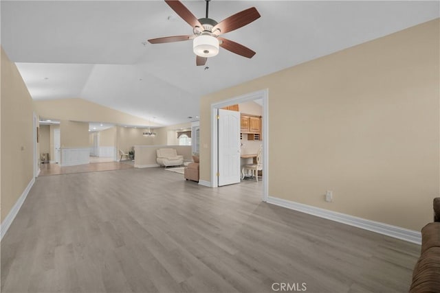 1641 Ford St, Redlands, CA 92373 - unfurnished living room featuring a ceiling fan, wood finished floors, lofted ceiling, baseboards, and a chandelier