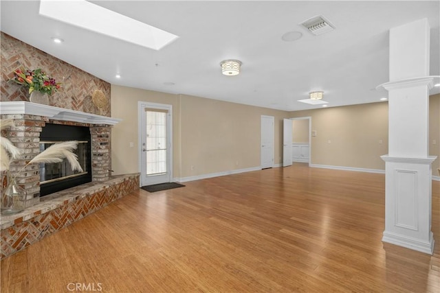 1641 Ford St, Redlands, CA 92373 - unfurnished living room featuring a fireplace, light wood-style floors, a skylight, baseboards, and recessed lighting