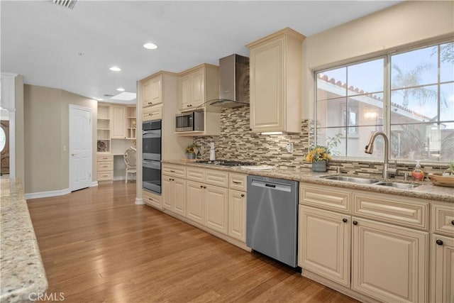 1641 Ford St, Redlands, CA 92373 - kitchen featuring appliances with stainless steel finishes, a sink, wall chimney exhaust hood, cream cabinetry, and decorative backsplash