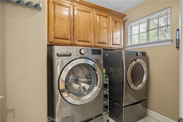 1641 Ford St, Redlands, CA 92373 - laundry room featuring separate washer and dryer, cabinet space, light tile patterned floors, and baseboards