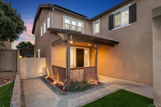 16231 Palomino Mesa Ct, San Diego, CA 92127 - property exterior at dusk with stucco siding and a porch