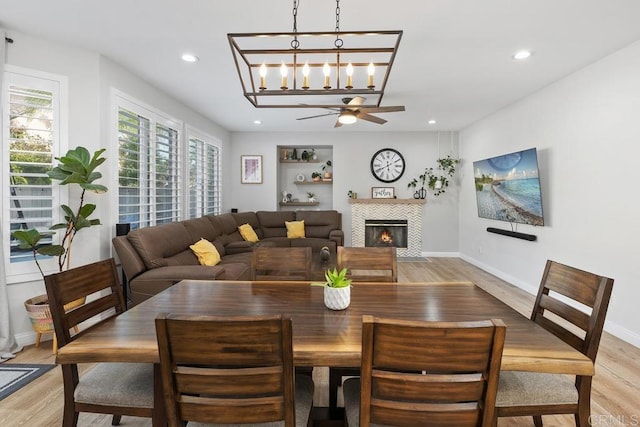 16231 Palomino Mesa Ct, San Diego, CA 92127 - dining space with light wood-style flooring, a fireplace, recessed lighting, a ceiling fan, and baseboards