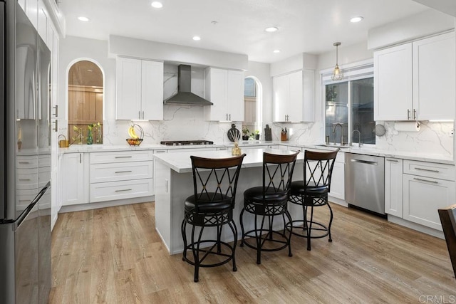 16231 Palomino Mesa Ct, San Diego, CA 92127 - kitchen with wall chimney exhaust hood, appliances with stainless steel finishes, a kitchen bar, backsplash, and a kitchen island