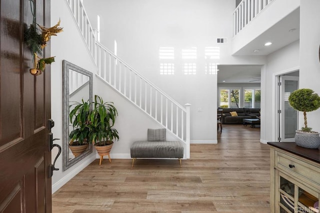 16231 Palomino Mesa Ct, San Diego, CA 92127 - foyer entrance with light wood finished floors, a towering ceiling, stairway, baseboards, and recessed lighting