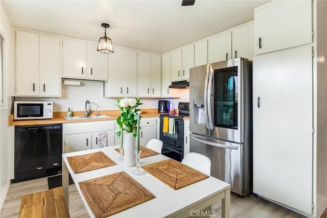 23292 Orange Ave Unit 6, Lake Forest, CA 92630 - kitchen with black appliances, under cabinet range hood, a sink, light countertops, and light wood-style floors