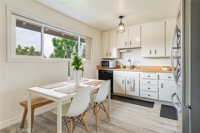 23292 Orange Ave Unit 6, Lake Forest, CA 92630 - kitchen with freestanding refrigerator, white microwave, a sink, dishwasher, and light wood-style floors