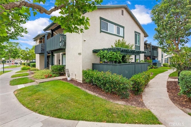 23292 Orange Ave Unit 6, Lake Forest, CA 92630 - view of home's exterior with stucco siding, a lawn, and a balcony