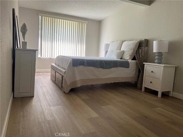 13962 El Dorado Dr Unit M2-60E, Seal Beach, CA 90740 - bedroom with light wood-style flooring, a textured ceiling, and baseboards