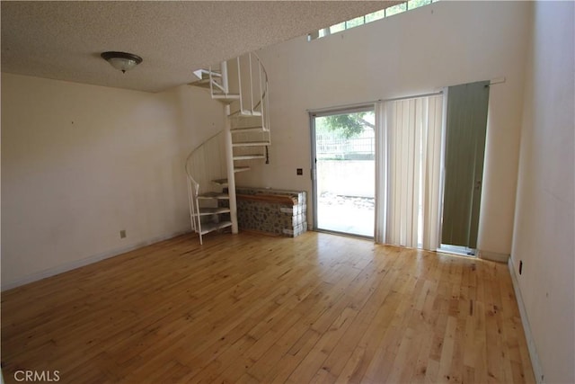 23362 La Mar Unit A, Mission Viejo, CA 92691 - unfurnished living room with wood-type flooring, stairway, a textured ceiling, and baseboards