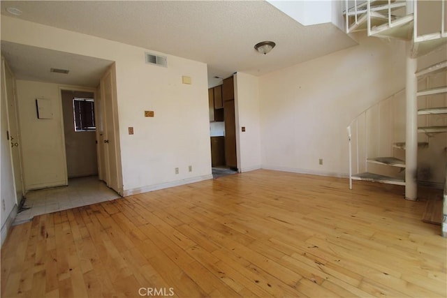 23362 La Mar Unit A, Mission Viejo, CA 92691 - unfurnished living room with light wood finished floors, stairway, and baseboards