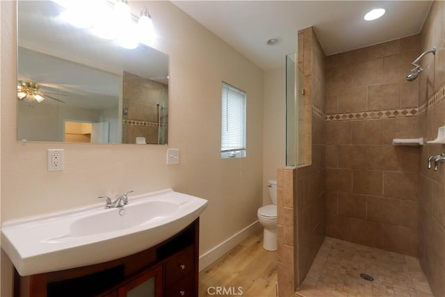 10624 Shellyfield Rd, Downey, CA 90241 - full bathroom featuring toilet, vanity, wood finished floors, a tile shower, and baseboards