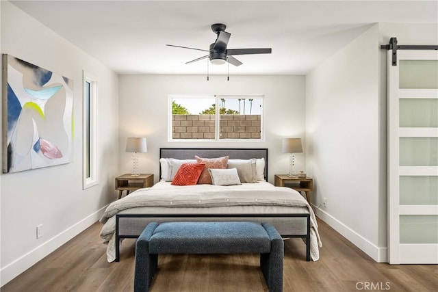9802 Effingham Dr, Huntington Beach, CA 92646 - bedroom featuring a barn door, baseboards, wood finished floors, and a ceiling fan