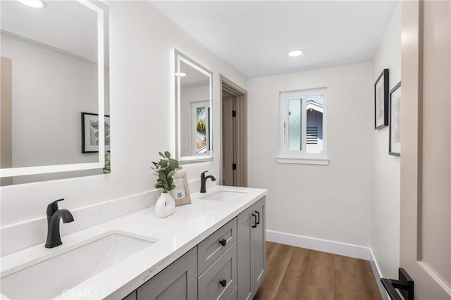 9802 Effingham Dr, Huntington Beach, CA 92646 - bathroom with double vanity, recessed lighting, wood finished floors, and baseboards