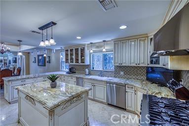 19162 Liggett St, Northridge, CA 91324 - kitchen featuring dishwasher, a peninsula, backsplash, light stone countertops, and pendant lighting