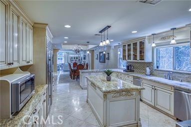 19162 Liggett St, Northridge, CA 91324 - kitchen featuring appliances with stainless steel finishes, healthy amount of natural light, a sink, glass insert cabinets, and recessed lighting