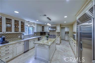 19162 Liggett St, Northridge, CA 91324 - kitchen with stainless steel appliances, tasteful backsplash, glass insert cabinets, recessed lighting, and under cabinet range hood