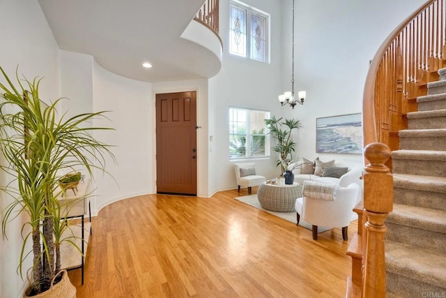 1026 Turnstone Rd, Carlsbad, CA 92011 - entrance foyer featuring stairway, wood finished floors, a chandelier, a towering ceiling, and baseboards