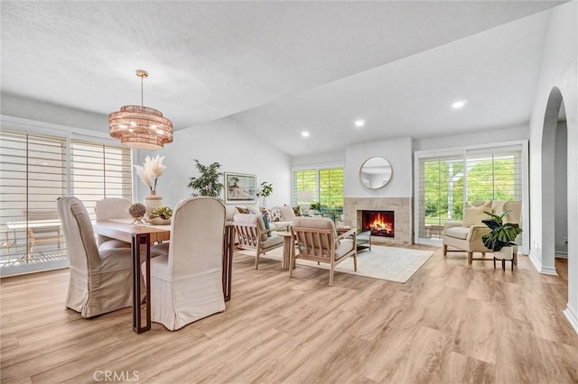28103 Espinoza, Mission Viejo, CA 92692 - dining space with a warm lit fireplace, light wood-style flooring, lofted ceiling, a chandelier, and arched walkways