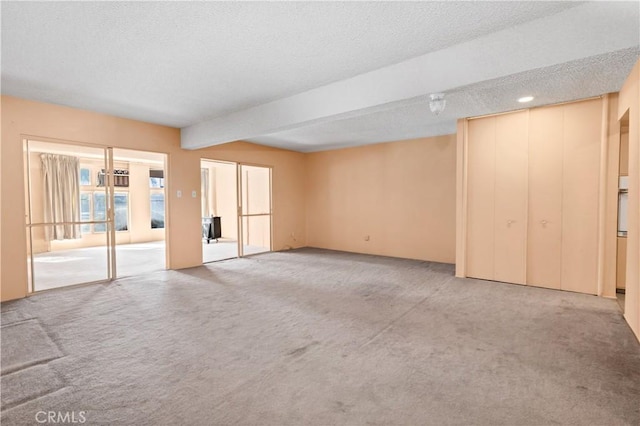 332 E 7th St, San Jacinto, CA 92583 - unfurnished living room featuring carpet floors, a textured ceiling, and beam ceiling