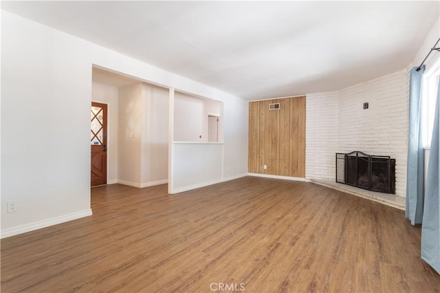 15903 Bryant St, North Hills, CA 91343 - unfurnished living room with light wood finished floors, a brick fireplace, and baseboards