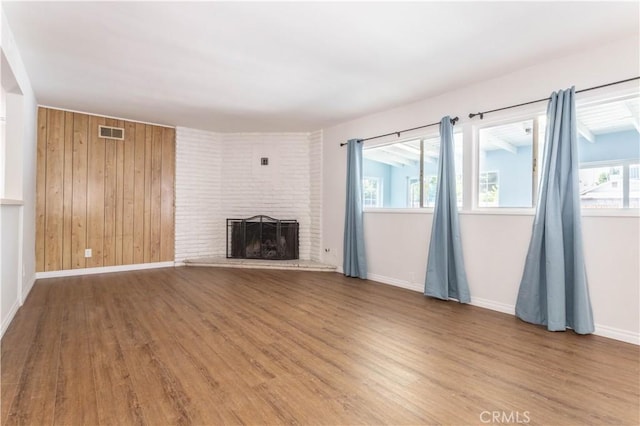 15903 Bryant St, North Hills, CA 91343 - unfurnished living room featuring wood finished floors, a fireplace, baseboards, and wood walls