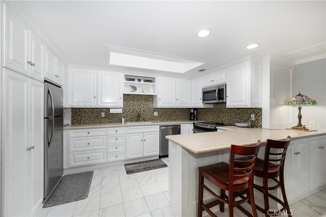 1420 Northwood Rd Unit 241C, Seal Beach, CA 90740 - kitchen featuring stainless steel appliances, a peninsula, white cabinets, light countertops, and a sink