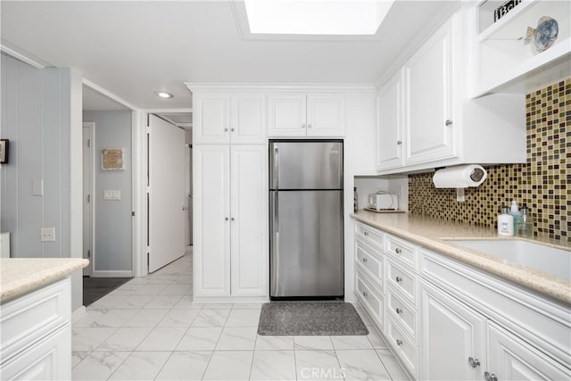 1420 Northwood Rd Unit 241C, Seal Beach, CA 90740 - kitchen with freestanding refrigerator, light countertops, white cabinetry, light marble finish flooring, and recessed lighting