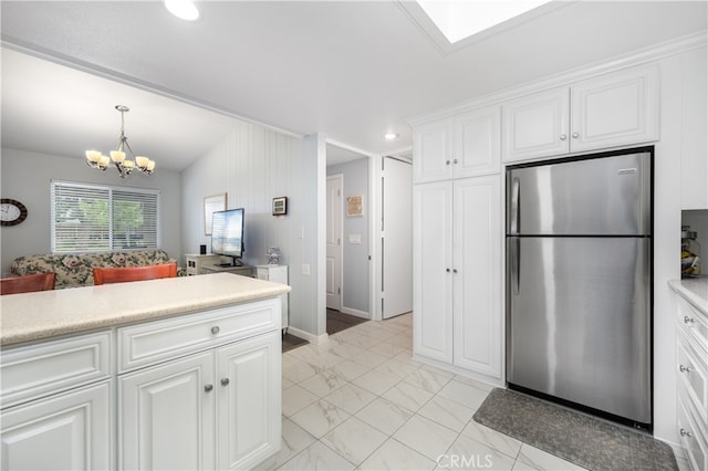 1420 Northwood Rd Unit 241C, Seal Beach, CA 90740 - kitchen with freestanding refrigerator, light countertops, light marble finish floors, a chandelier, and white cabinets
