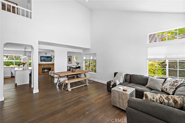 24532 Kings, Laguna Niguel, CA 92677 - living room with a high ceiling, arched walkways, a tiled fireplace, dark wood-style floors, and baseboards