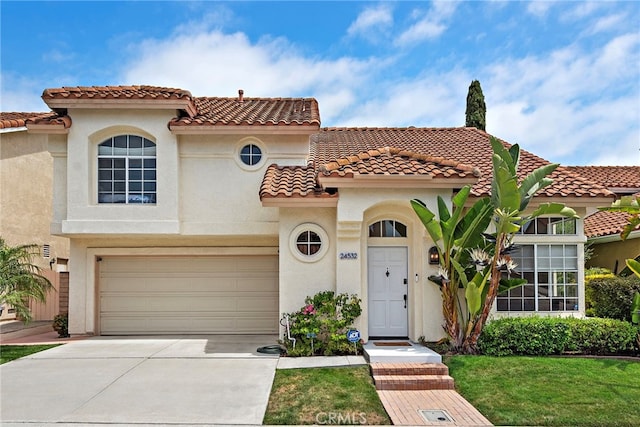 24532 Kings, Laguna Niguel, CA 92677 - mediterranean / spanish-style house featuring stucco siding, a tiled roof, driveway, an attached garage, and a front lawn