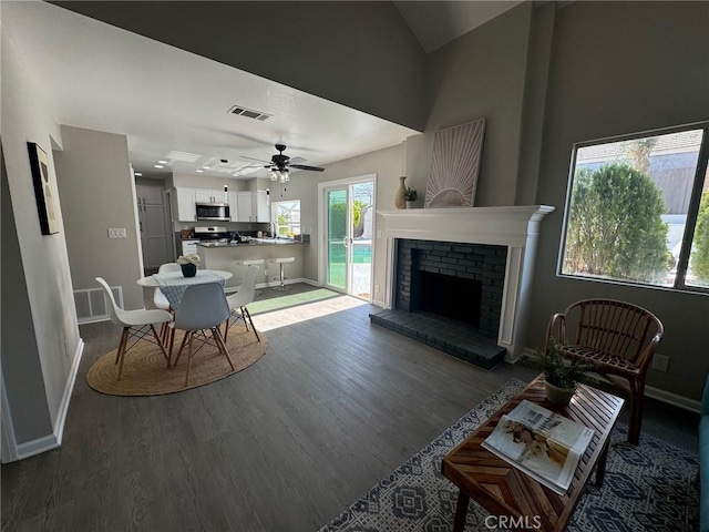 38422 Puma Ln, Palmdale, CA 93551 - living area featuring baseboards, dark wood-style flooring, ceiling fan, a brick fireplace, and high vaulted ceiling